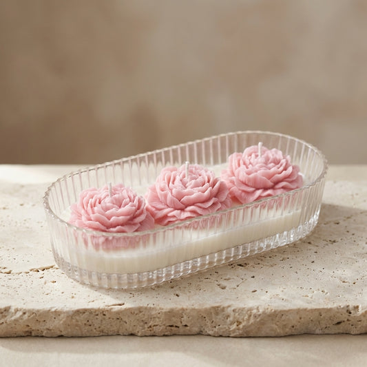 Blushing peony trio centerpiece burning with three wicks, styled beautifully as a romantic focal point on an elegant dining table.
