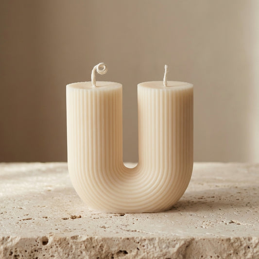 Fluted U-shape double wick candle styled beautifully as a modern, minimalist statement piece on an elegant coffee table.