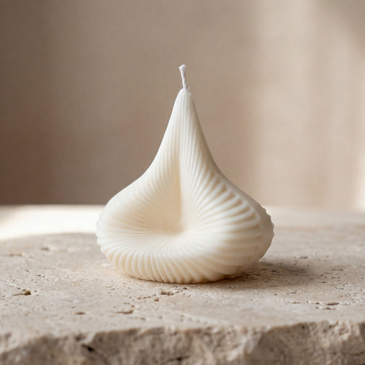 Sculptural swirl drop candle styled beautifully as an elegant geometric centerpiece on a dining table.