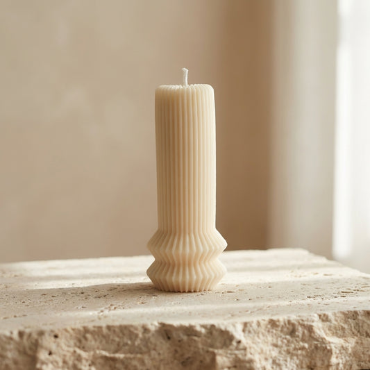 Architectural fluted pillar candle styled as a modern minimalist accent on a beautifully curated coffee table display.