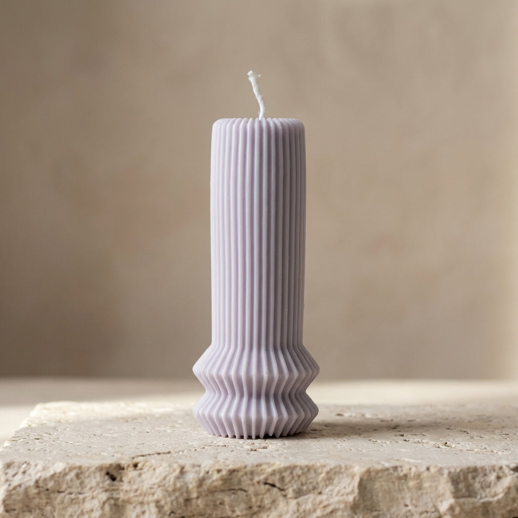 Architectural fluted pillar candle styled as a modern minimalist accent on a beautifully curated coffee table display.