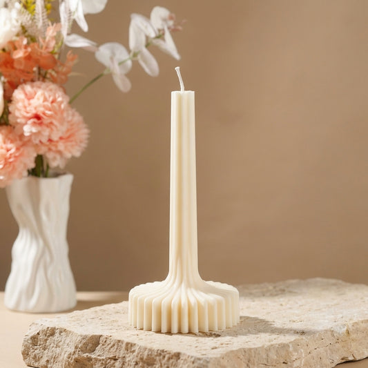 Close-up of a hand-poured soy wax architectural ribbed column candle highlighting its continuous fluted texture and stable sunburst base.