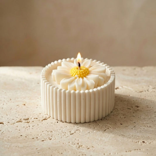 Close-up of a handcrafted ribbed gypsum vessel featuring a hyper-realistic, hand-poured soy wax daisy with a cheerful yellow center.