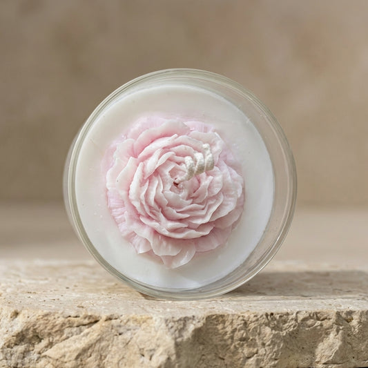 Blushing peony glass candle styled beautifully as a sophisticated, romantic floral accent on an elegant vanity setting.