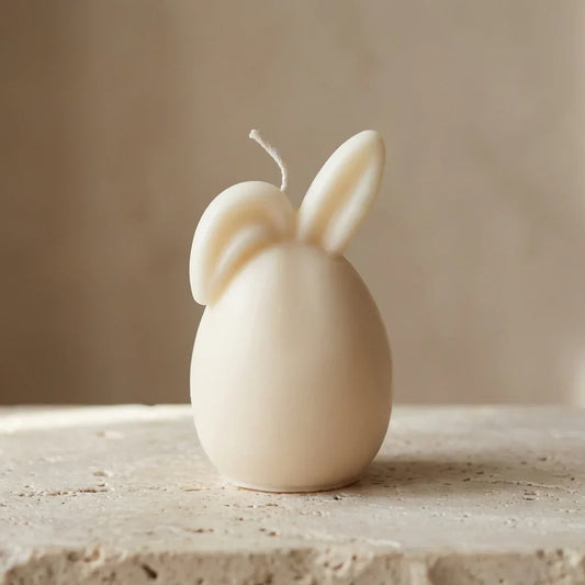 Close-up of a hand-poured soy wax bunny egg candle highlighting its smooth minimalist silhouette and playful ears.