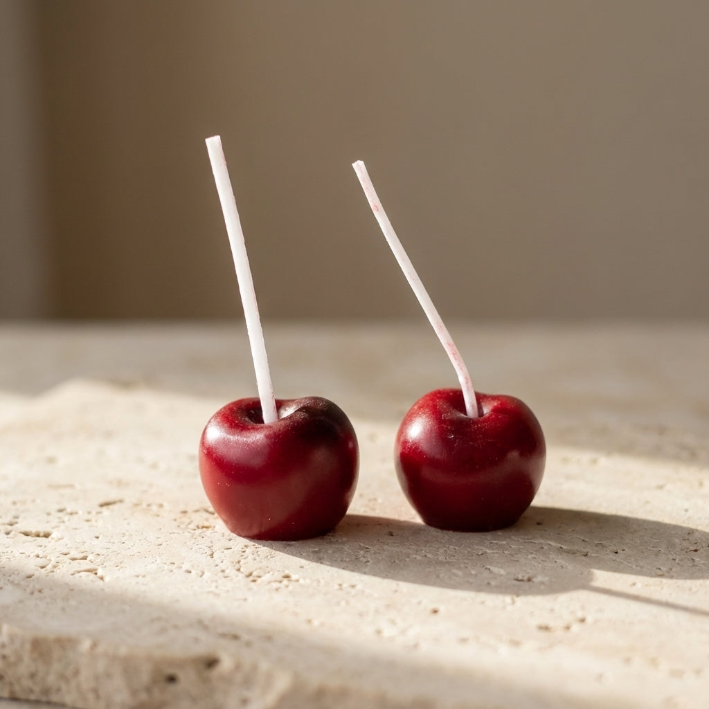 Cherry cake candles styled playfully as unique, vibrant toppers on a beautiful birthday cake.