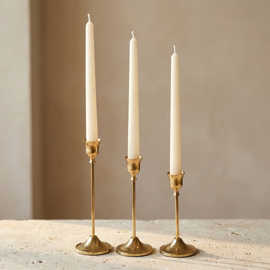 Classic taper candles styled elegantly in minimalist holders on a romantic, festive dining table centerpiece.