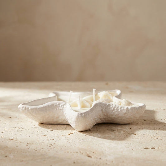 Coastal starfish candle burning with three wicks, styled beautifully as a serene ocean-inspired aesthetic addition to a bright bathroom oasis.