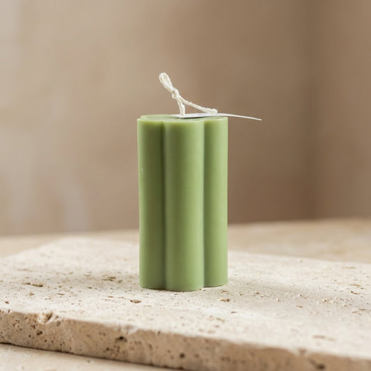 Close-up of a hand-poured soy wax daisy pillar candle highlighting its soft, petal-like edges.