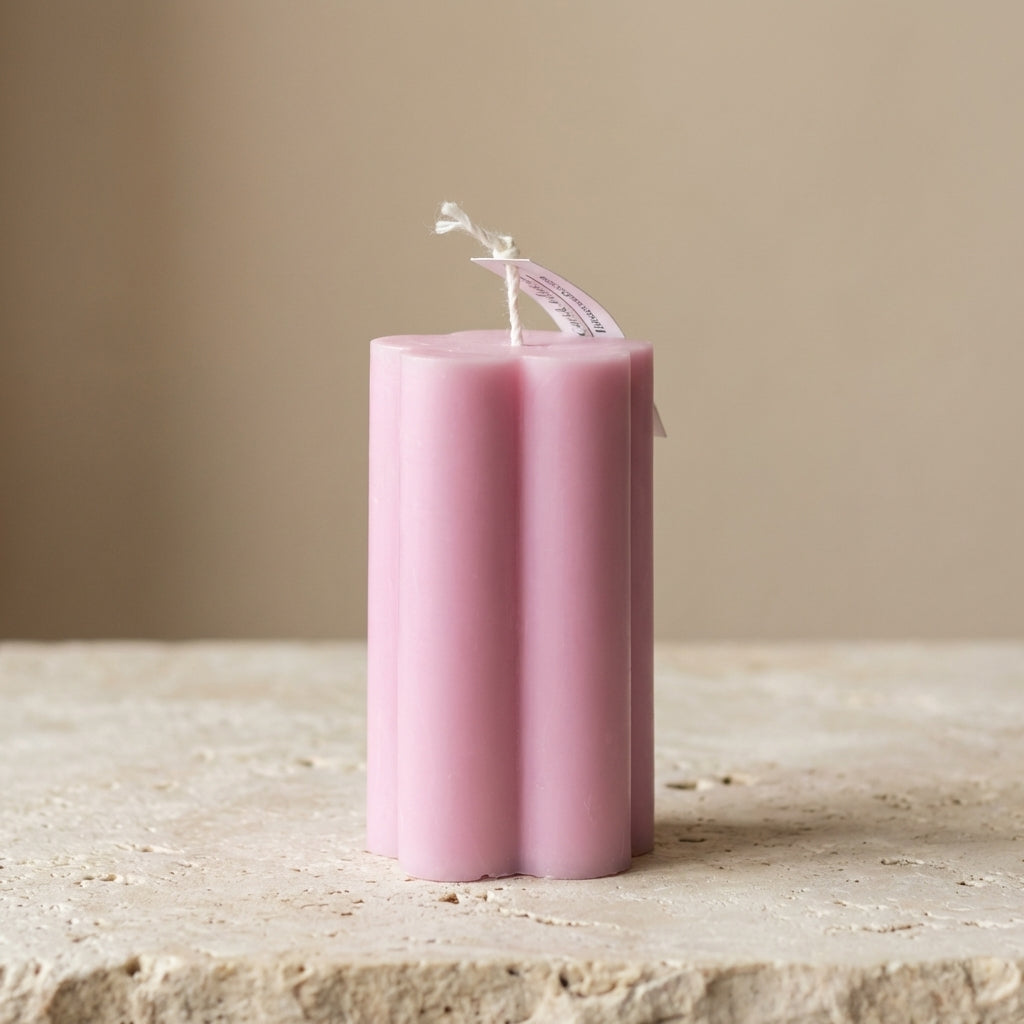 Close-up of a hand-poured soy wax daisy pillar candle highlighting its soft, petal-like edges.
