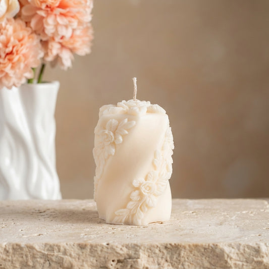 Close-up of a hand-poured soy wax embossed rose swirl candle highlighting its twisting silhouette and intricate 3D floral pattern.
