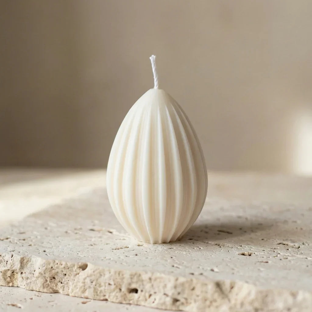 White textured candle on a stone surface with a neutral background