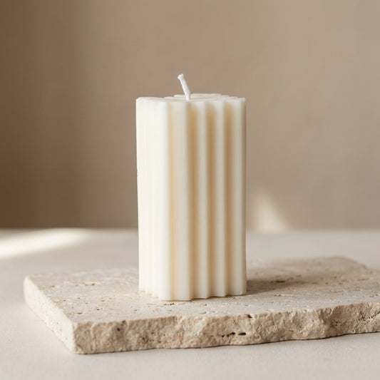 Close-up of a hand-poured soy wax geometric chevron pillar candle highlighting its continuous ribbed lines and zigzag cross-section.