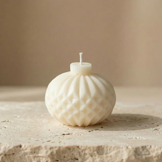Close-up of a hand-poured soy wax geometric diamond sphere candle highlighting its intricate quilted texture and facets.