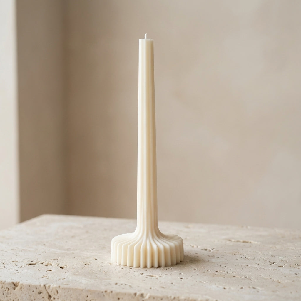 Close-up of a hand-poured soy wax grand architectural ribbed column candle highlighting its sweeping fluted texture and stable sunburst base.