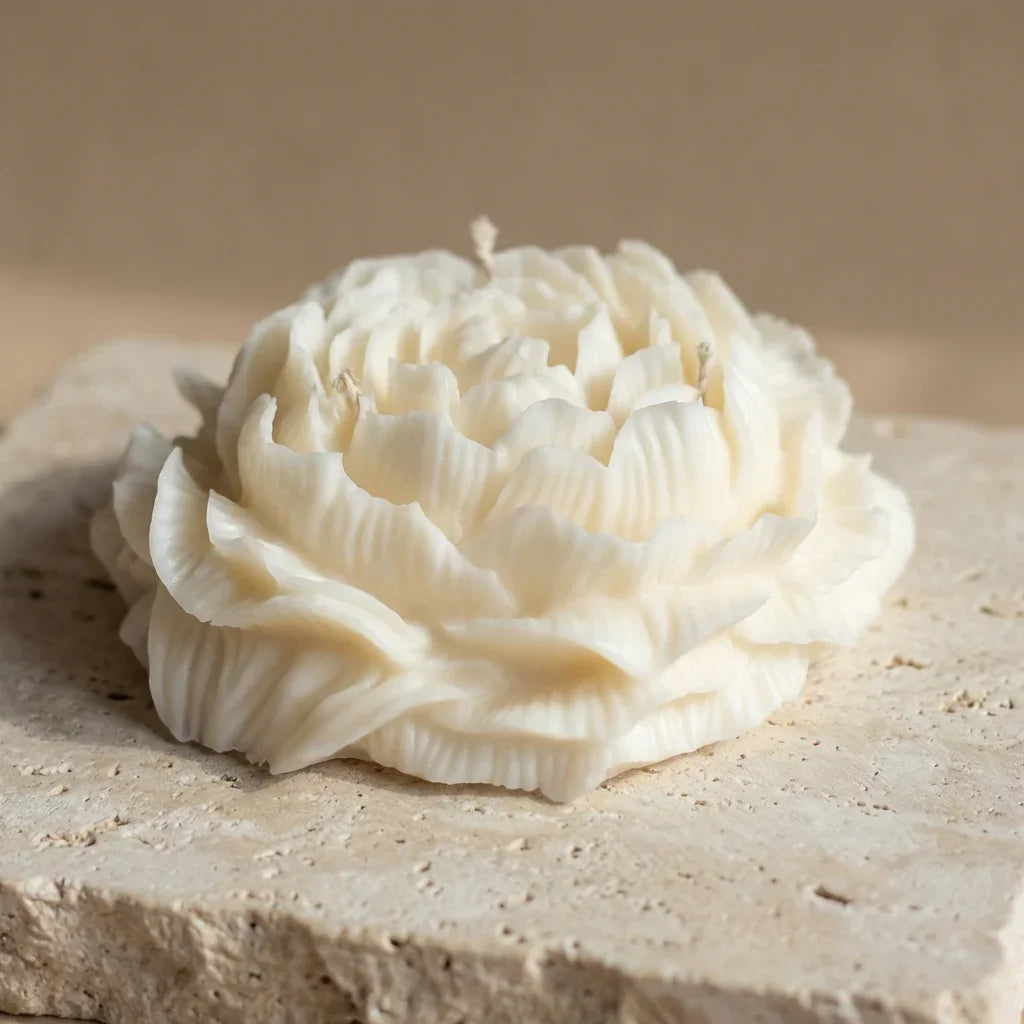 Close-up of a hand-poured soy wax grand peony centerpiece candle highlighting its hyper-realistic, ruffled floral petals and three wicks.