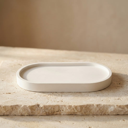 Close-up of a handcrafted oval candle tray highlighting its sleek, minimalist gypsum silhouette and smooth varnished finish.