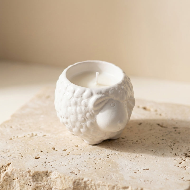 Little lamb candle styled beautifully as a sweet, farmhouse-inspired decor piece on a wooden shelf in a cozy baby nursery.
