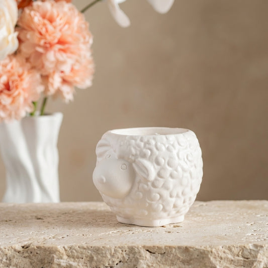 Close-up of a handcrafted sheep-shaped gypsum candle highlighting its textured, double-varnished finish and pure soy wax filling.