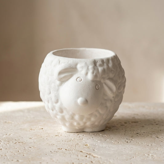 Adorable little lamb gypsum candle styled beautifully as a sweet, cozy decor piece in a calming baby's nursery.