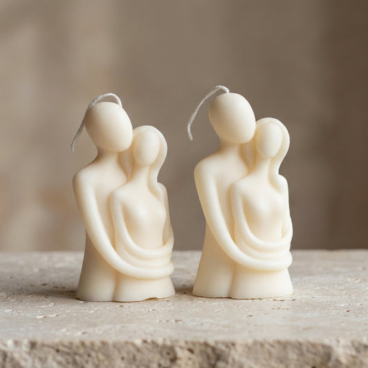 Close-up of a hand-poured soy wax lovers sculpture candle highlighting its smooth, minimalist abstract design of a couple embracing.
