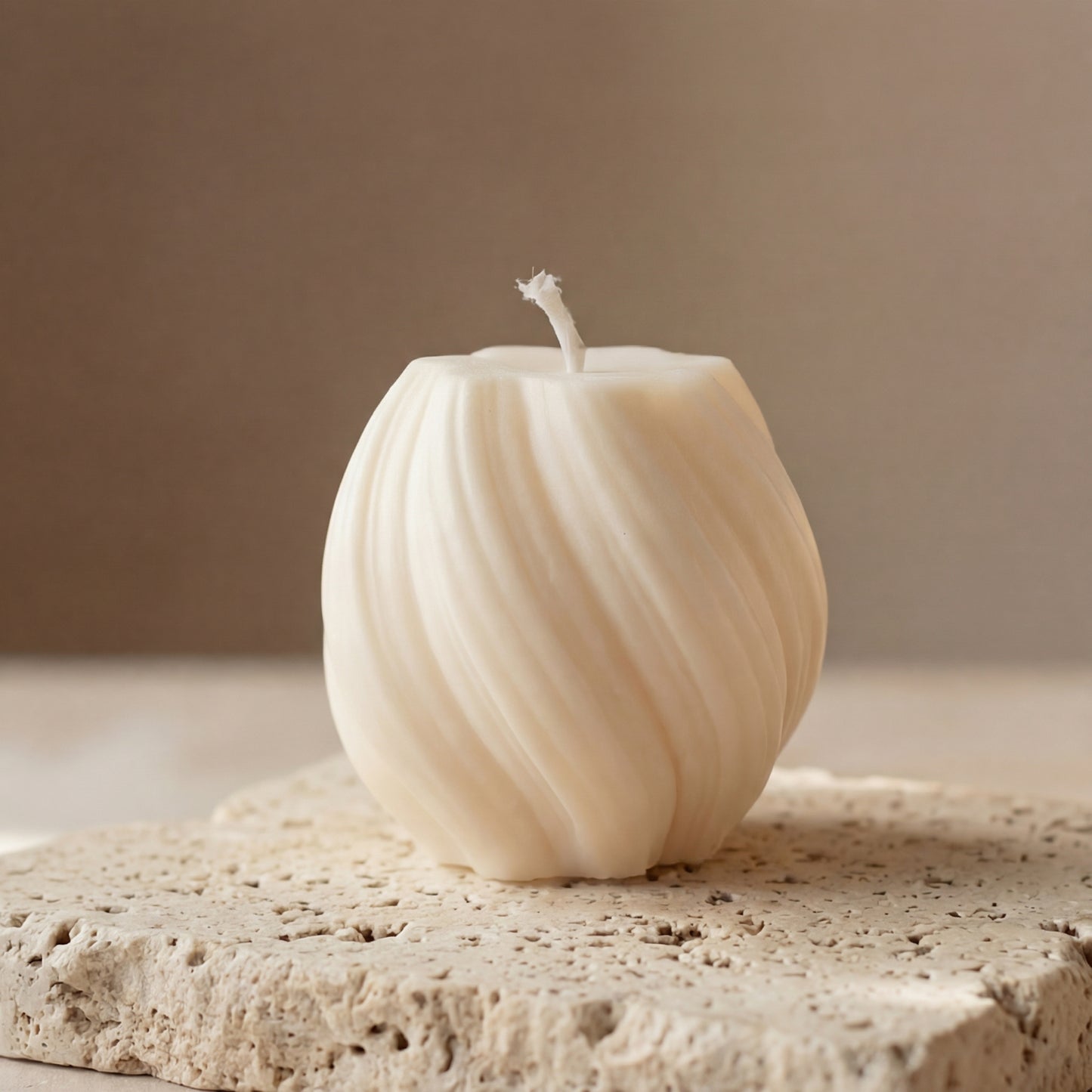 Close-up of a hand-poured soy wax mini swirl globe candle highlighting its continuous ribbed lines and twisted texture.
