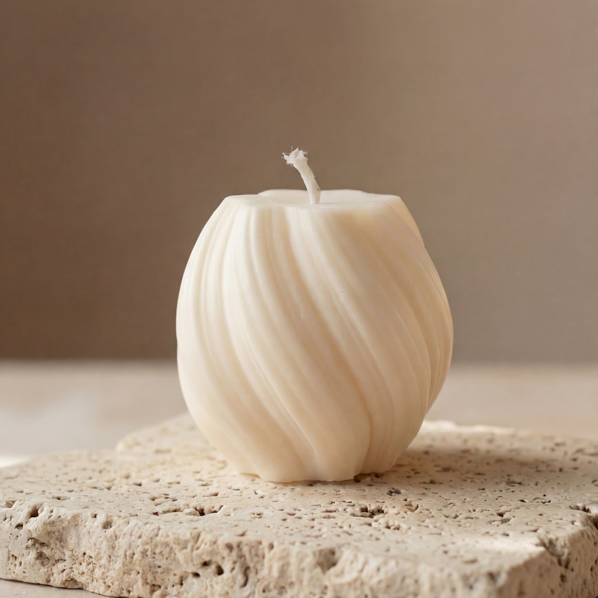 Close-up of a hand-poured soy wax mini swirl globe candle highlighting its continuous ribbed lines and twisted texture.