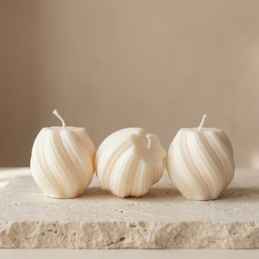 Three mini swirl globe candle styled beautifully as a delicate, modern accent on a cozy bedside nightstand.