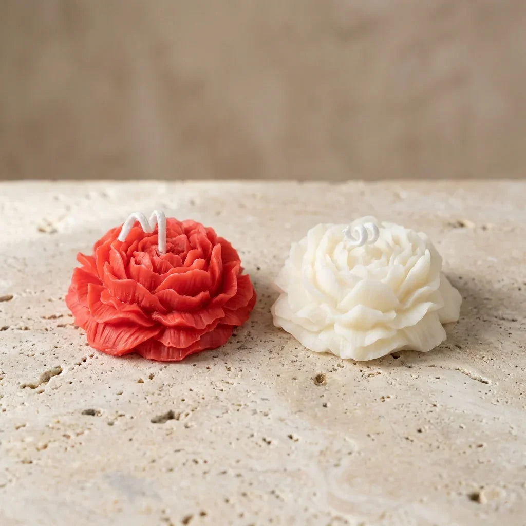 Close-up of a hand-poured uncolored soy wax miniature ivory ruffled blossom candle highlighting its delicate, multi-layered ranunculus petals.