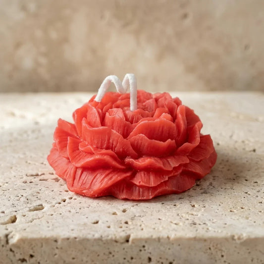 Close-up of a hand-poured uncolored soy wax miniature ivory ruffled blossom candle highlighting its delicate, multi-layered ranunculus petals.