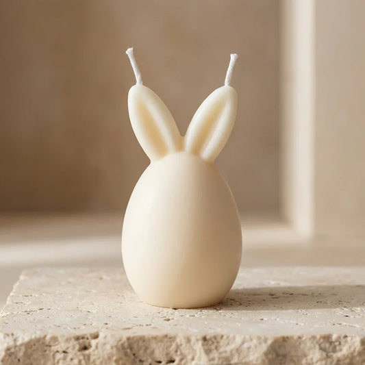 Close-up of a hand-poured soy wax dual-wick Easter bunny candle highlighting its smooth, minimalist egg shape and two bunny ears.