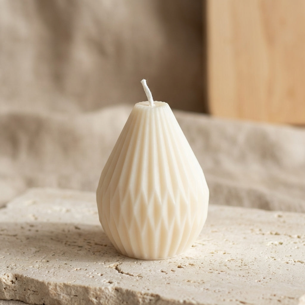 Close-up of a hand-poured soy wax petite faceted teardrop candle highlighting its deeply carved, diamond-like geometric pattern.