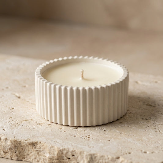 Close-up of a handcrafted ribbed gypsum vessel featuring hand-poured natural white soy wax and a single cotton wick.