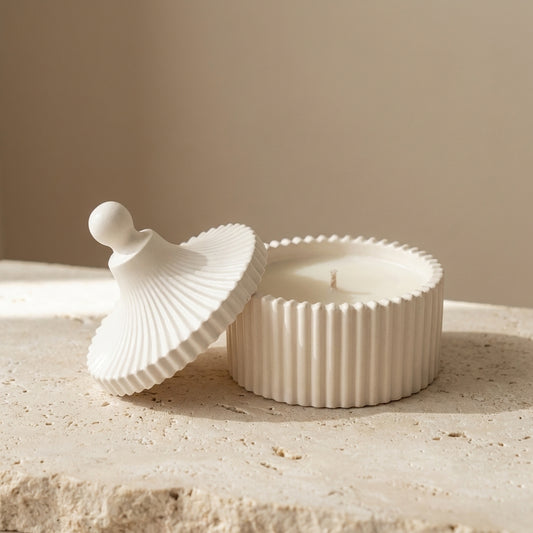 Close-up of a handcrafted ribbed gypsum vessel and matching finial lid, featuring hand-poured natural white soy wax inside.
