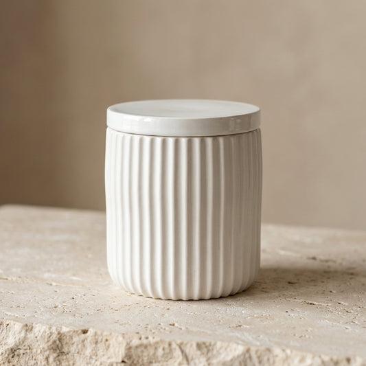 Ribbed minimalist jar candle with its flat lid resting nearby, styled beautifully as a modern, sophisticated canister on a sleek bathroom vanity.