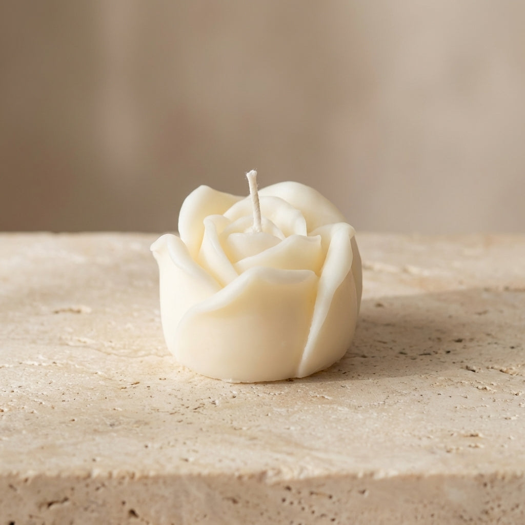Rose-shaped candle on a textured surface with a neutral background