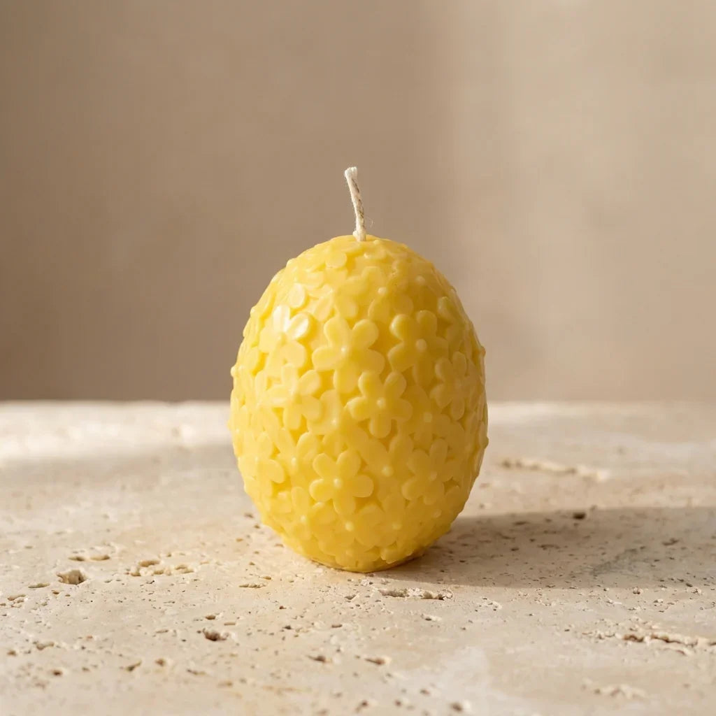 Yellow textured candle on a neutral background