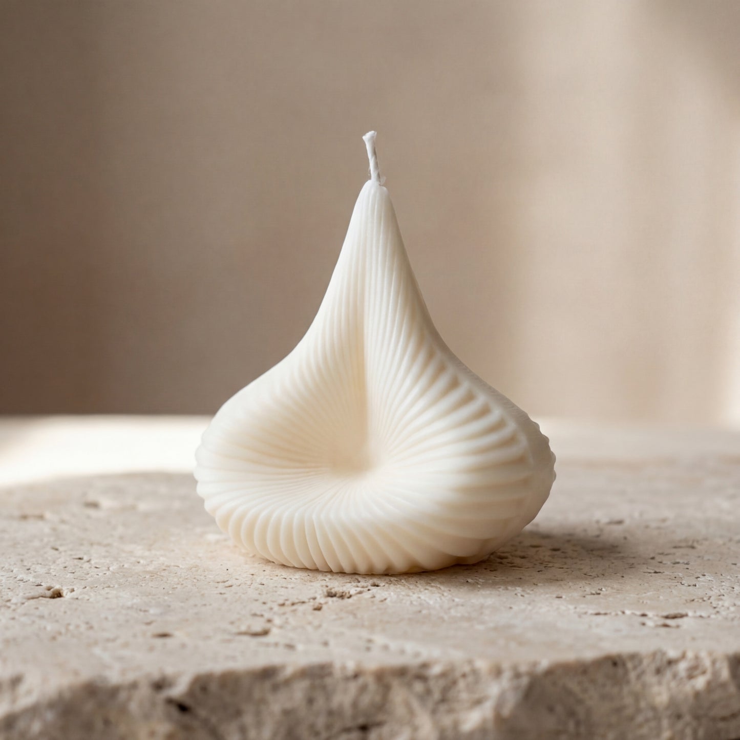 Sculptural swirl drop candle styled beautifully as an elegant geometric centerpiece on a dining table.