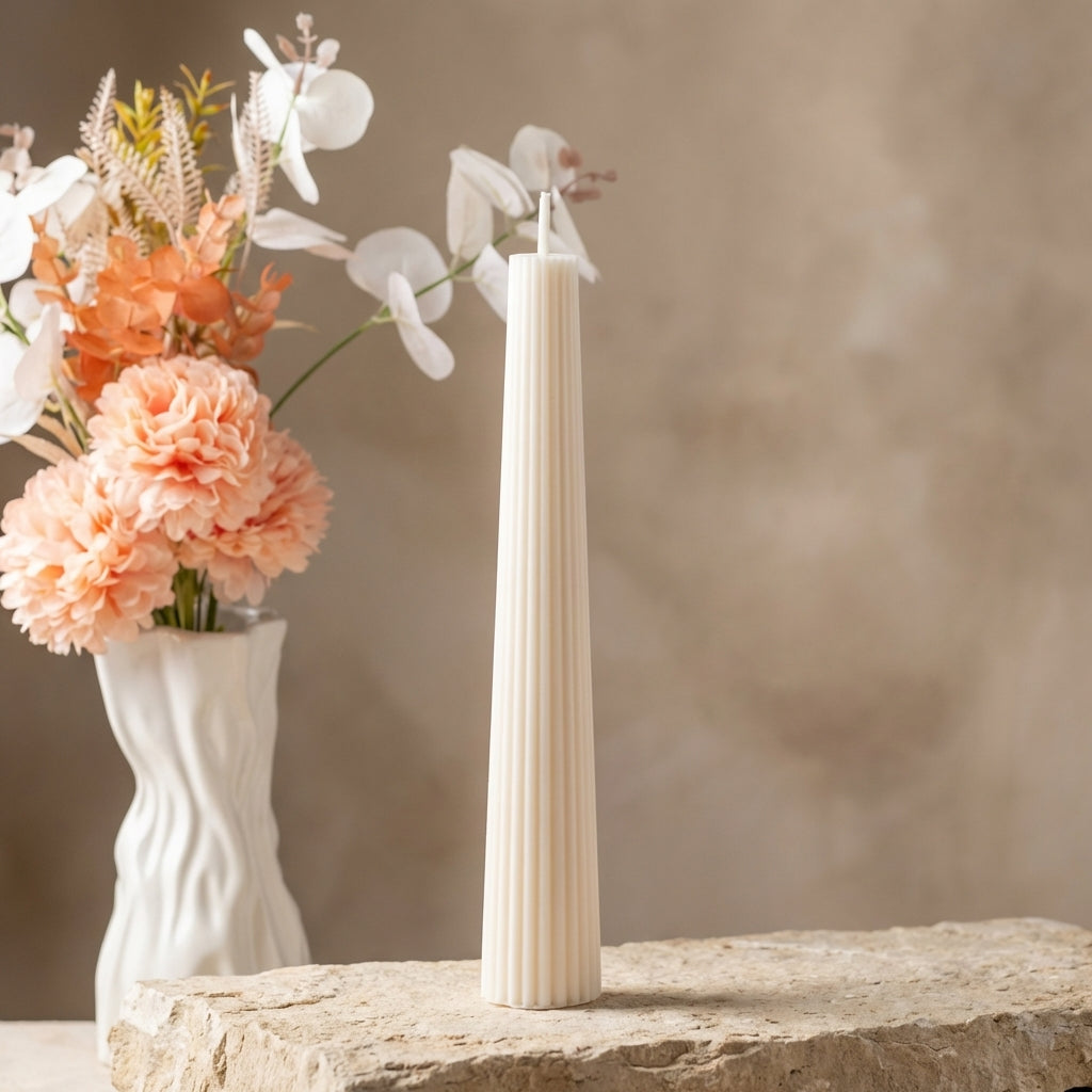 Close-up of a hand-poured soy wax tall fluted pillar candle highlighting its beautifully tapered silhouette and vertical ribbed details.