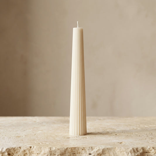 Tall fluted pillar candle styled beautifully as a striking, freestanding modern centerpiece in an elegant room setting.