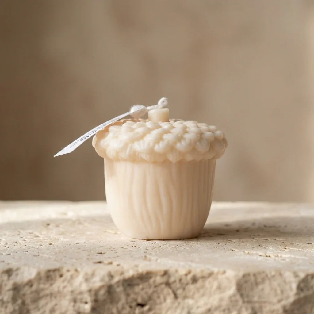 Decorative acorn-shaped object with a textured surface on a stone surface.