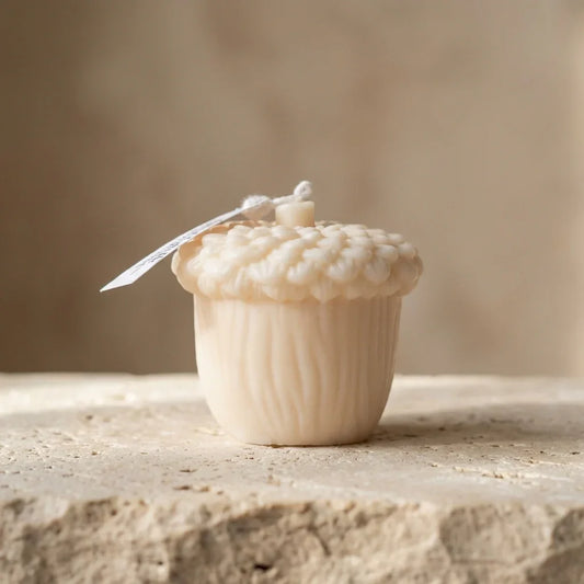 Decorative acorn-shaped object with a textured surface on a stone surface.
