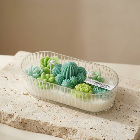 Close-up of a two-wick natural soy candle featuring a lush arrangement of detailed green wax succulents and cacti resting on top.