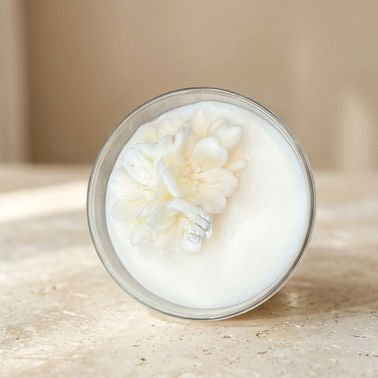 Creamy white product in a round container with a floral design on a beige background