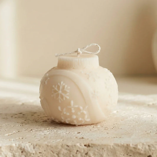 Close-up of a hand-poured soy wax snowflake bauble candle highlighting its classic Christmas ornament shape and delicate embossed details.