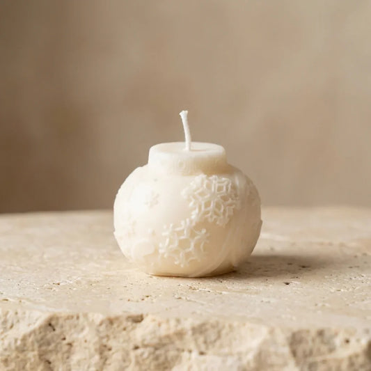 Sculptural snowflake bauble candle styled beautifully as a cozy, nostalgic accent on a festive holiday tablescape.