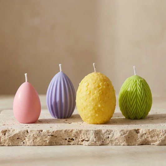 Close-up of a beautifully curated set of four hand-poured soy wax spring egg candles highlighting their distinct textures and smooth minimalism.