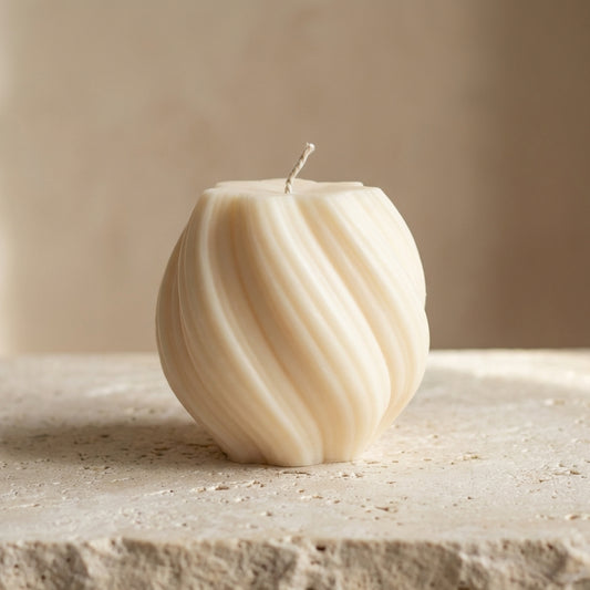 Close-up of a hand-poured soy wax swirl globe candle highlighting its continuous ribbed lines and twisted organic silhouette.