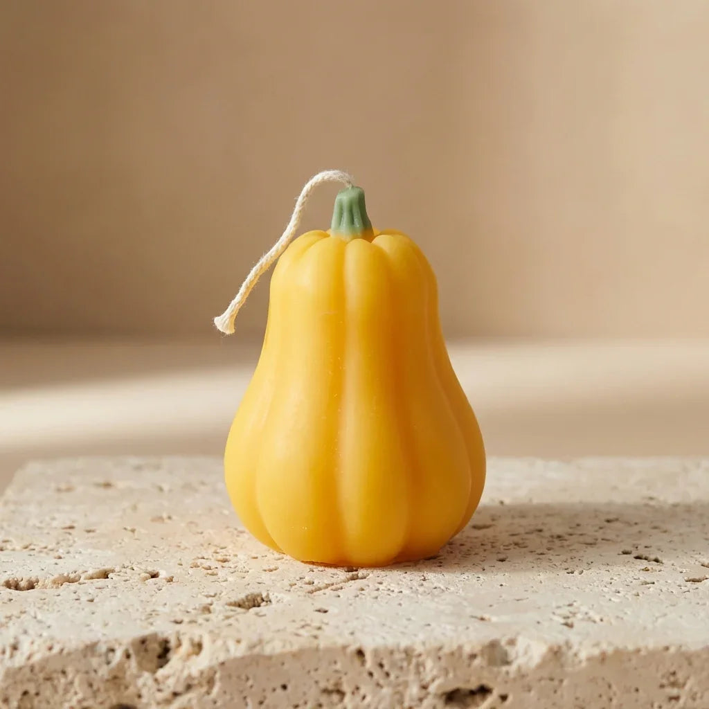 Yellow decorative pumpkin on a textured surface with a neutral background