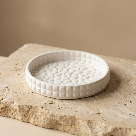 Textured gypsum tray styled beautifully as an aesthetic catch-all dish holding daily jewelry on a modern nightstand.